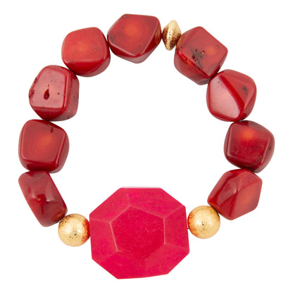 Bracelet with red beads and gold accents on a white background
