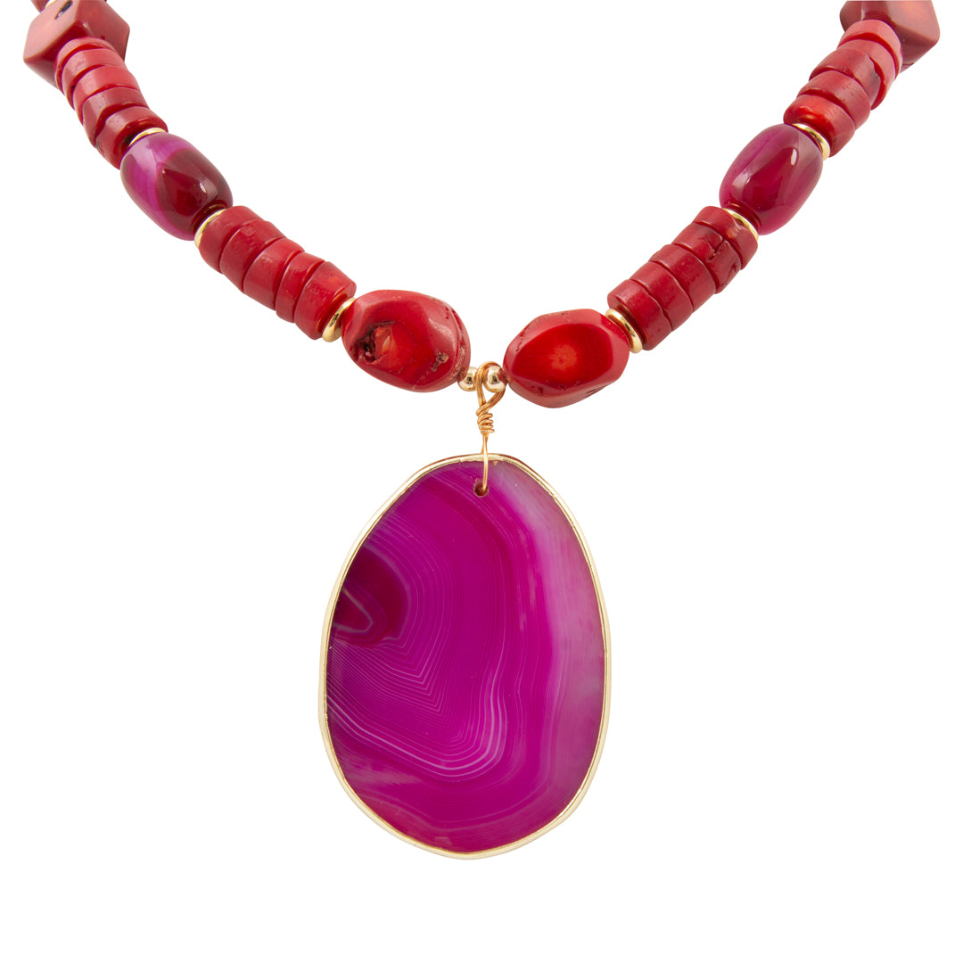 Necklace with red beads and a purple pendant on a white background