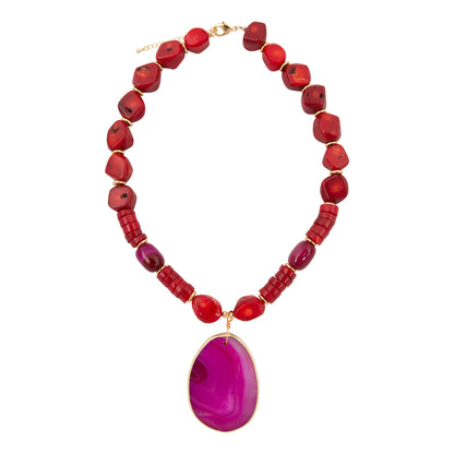 Necklace with red beads and a large purple pendant on a white background