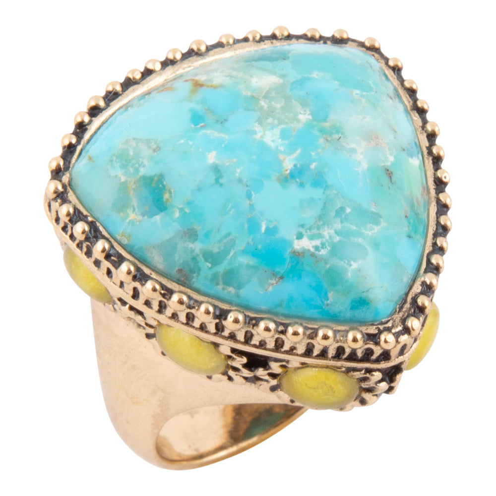 A large turquoise stone ring with a gold-toned beaded border and small yellow-green accents on the band, shown on a plain white background.