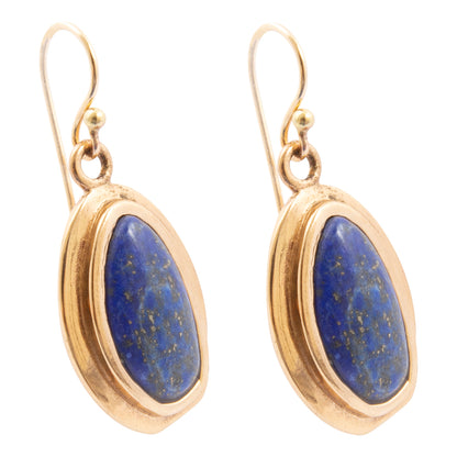 Gold earrings with blue stones on a white background