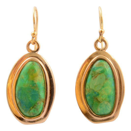 Gold earrings with green gemstones on a white background