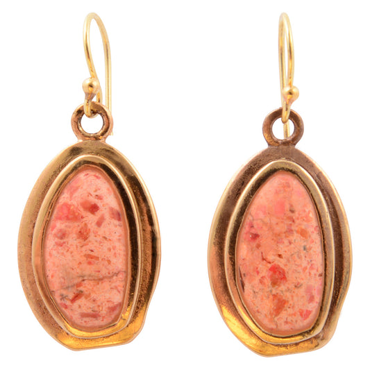 Pair of earrings with pink stone and gold frame on a white background