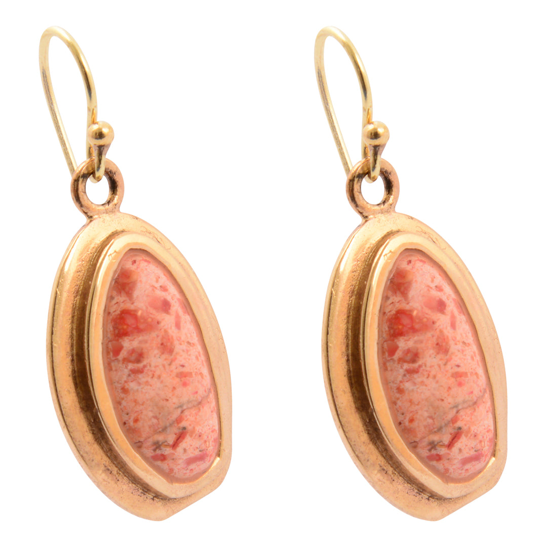 Gold earrings with pink stone inlays on a white background