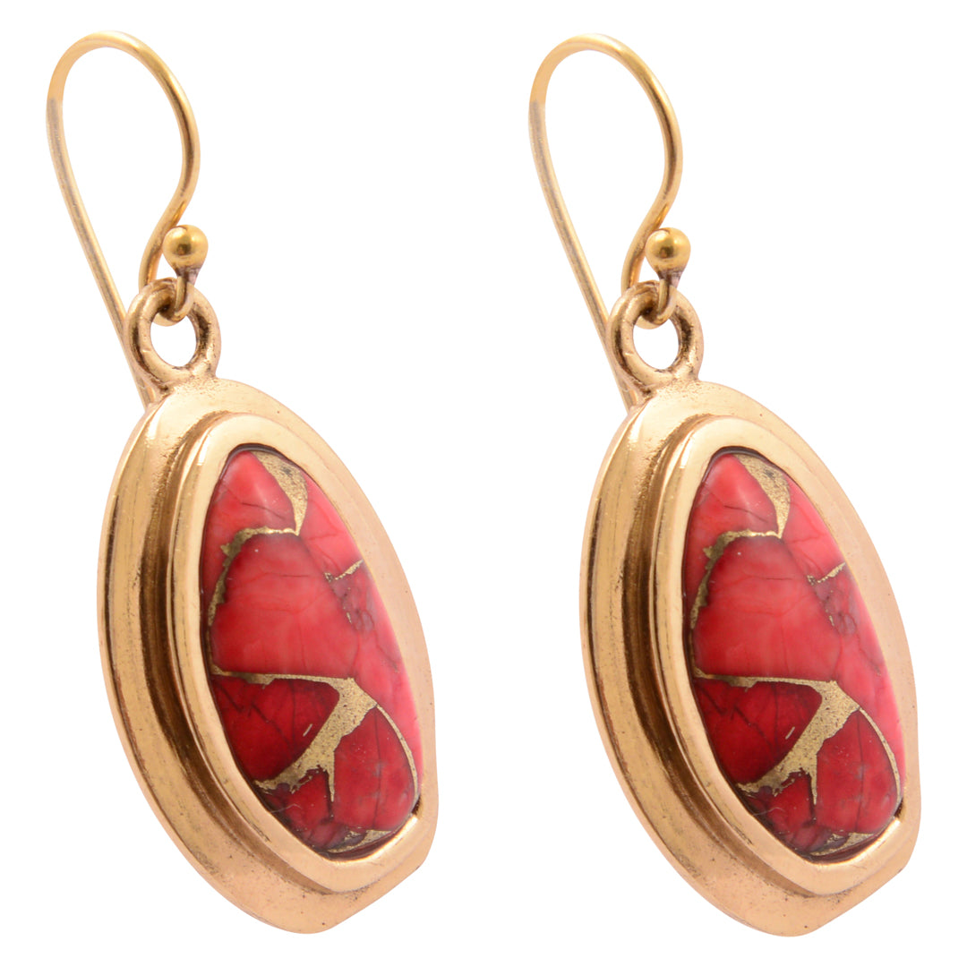 Gold earrings with red stone inlays on a white background