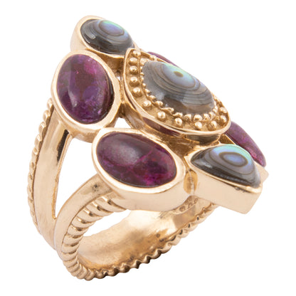 Gold ring with purple and gray gemstones on a white background