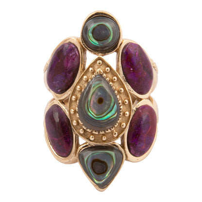 Gold ring with purple and green gemstones on a white background
