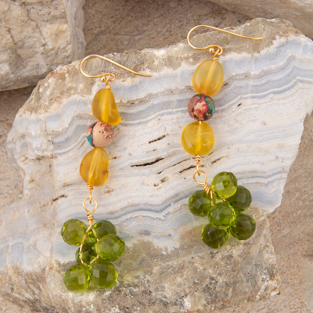 Green beaded earrings on a stone surface