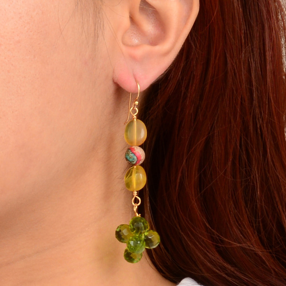 Close-up of an earring with colorful beads worn by a person with red hair.