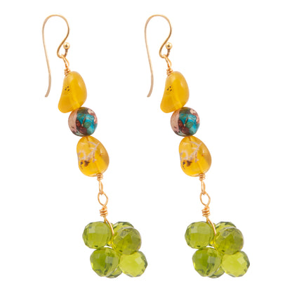Pair of earrings with yellow and green beads on a white background