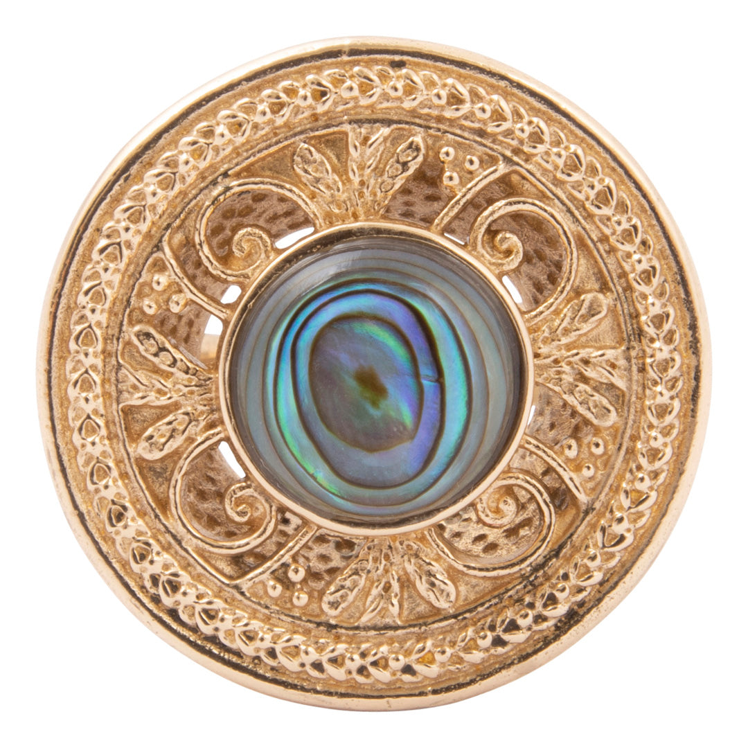 Decorative button with gold filigree and central abalone shell on a white background