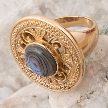 Gold ring with a blue stone on a textured surface