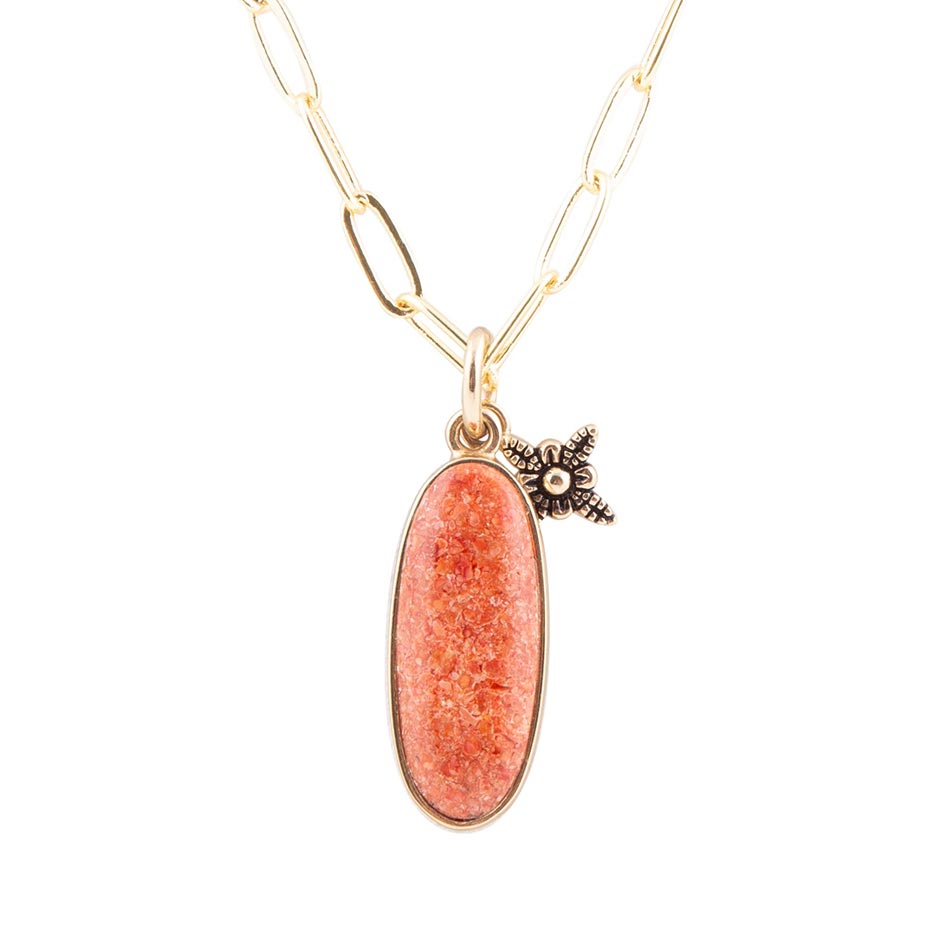 Necklace with a pink pendant and gold chain on a white background