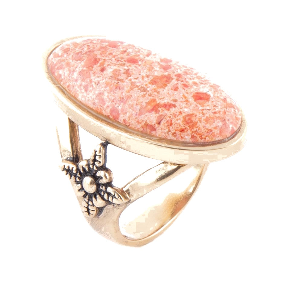 Ring with pink stone and gold accents on a white background