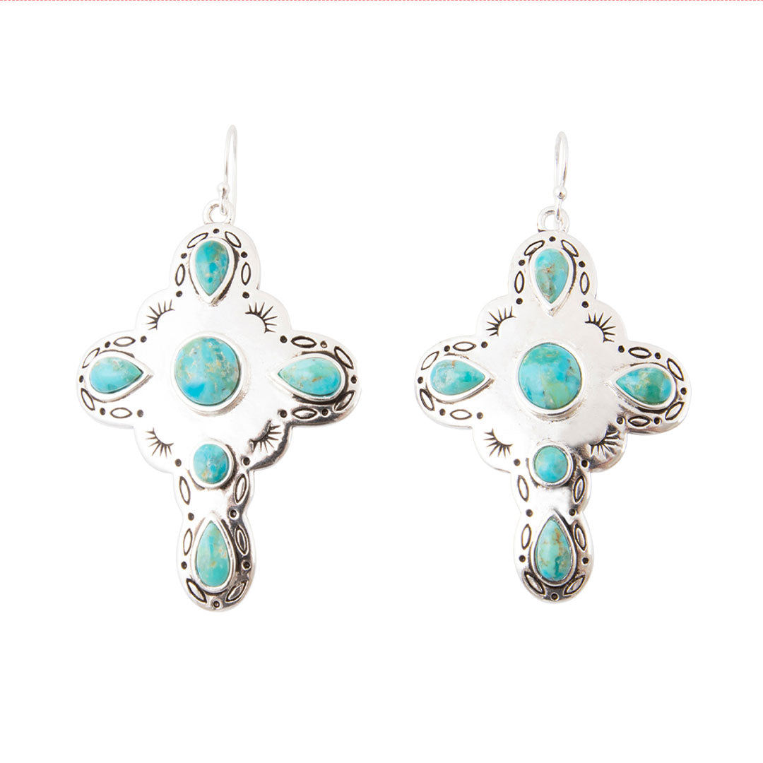 A pair of silver cross-shaped dangle earrings with turquoise stones, shown on a plain white background.