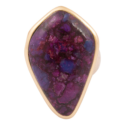 Ring with a purple gemstone and gold band on a white background