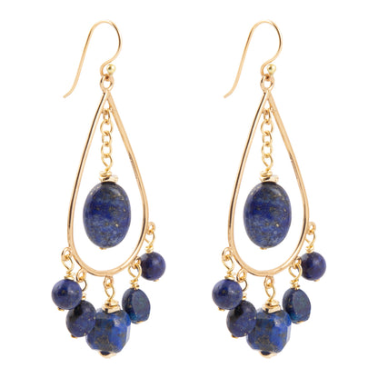 A pair of gold-tone dangle earrings featuring oval and round deep blue lapis lazuli stones, shown against a plain white background.