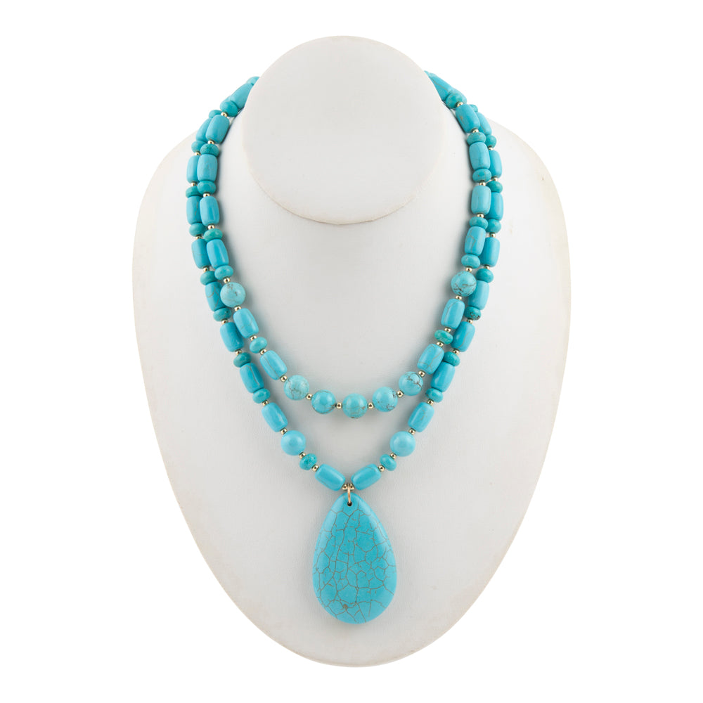 A two-strand turquoise beaded necklace with a large teardrop-shaped turquoise pendant, displayed on a white mannequin bust against a white background.