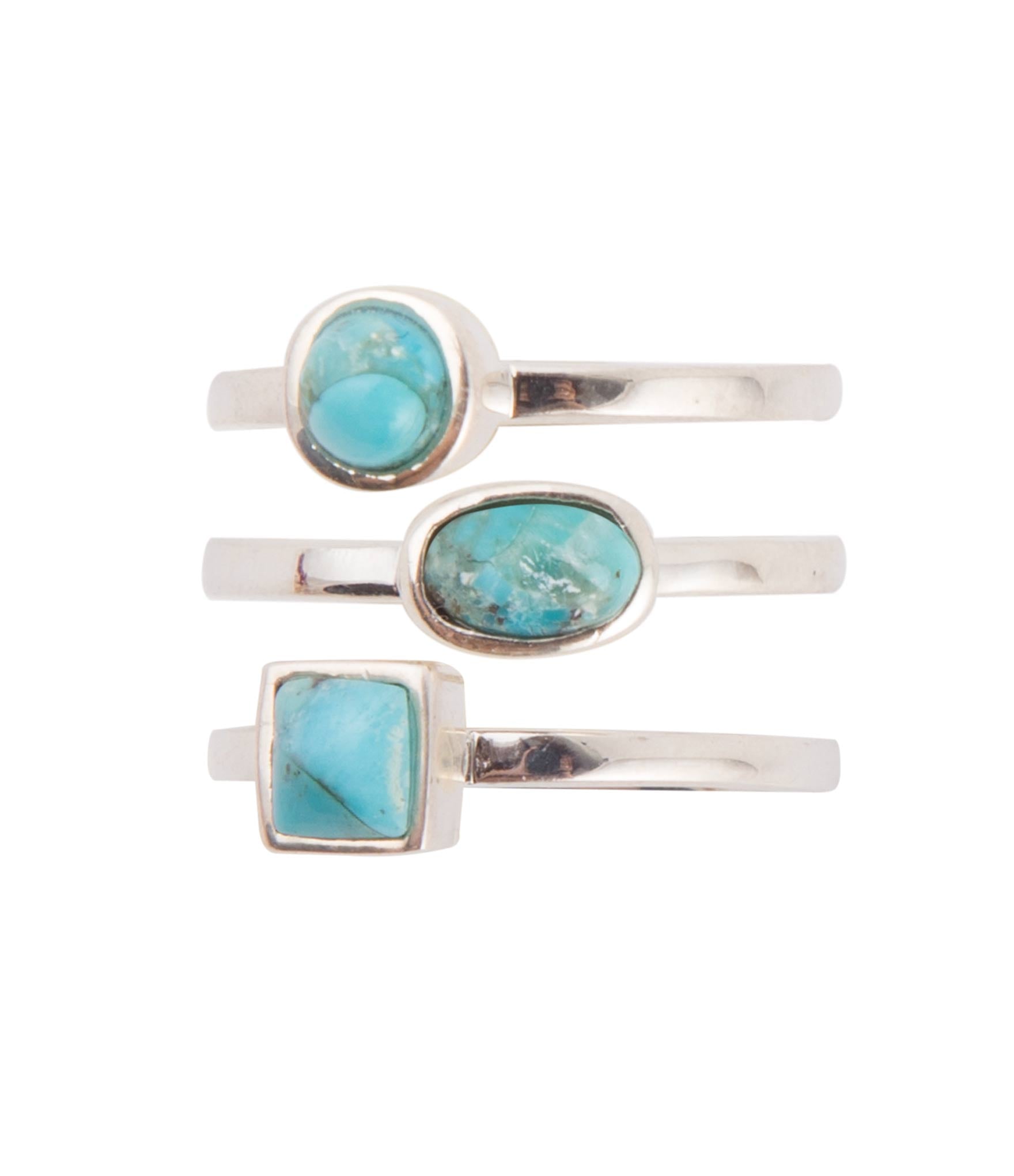 Three silver rings with turquoise stones on a white background