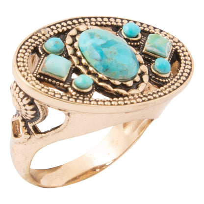 A gold-toned ring featuring a large oval turquoise center stone and four smaller turquoise stones set in an ornate, beaded metal frame, shown on a plain white background.