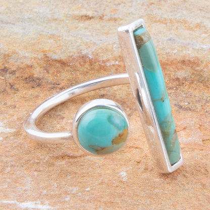 Turquoise stone ring with silver band on a wooden surface