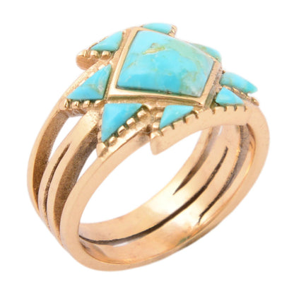 Gold ring with turquoise stones on a white background