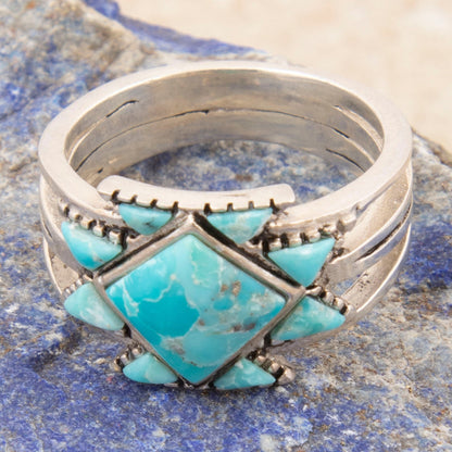 Silver ring with turquoise stone on a blue stone surface