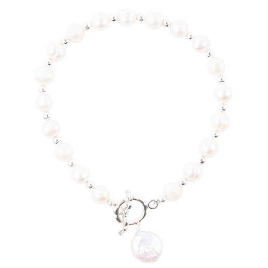 A beaded bracelet featuring white freshwater pearls separated by small silver spacer beads, finished with a silver toggle clasp and a dangling round white pearl charm.