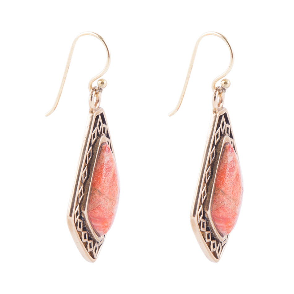 A pair of teardrop-shaped dangle earrings featuring a polished pinkish-orange stone in a silver-toned geometric bezel setting with fishhook wires, shown on a plain white background.
