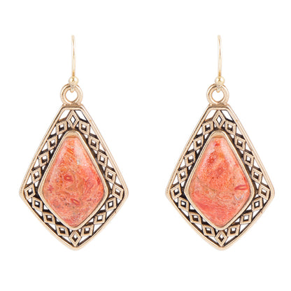 Pair of earrings with pink stone and gold frame on a white background