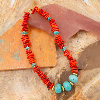 Bracelet with red and turquoise beads on a stone surface