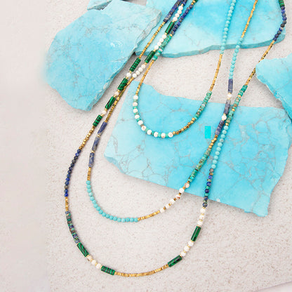 Beaded necklaces on turquoise stone surface