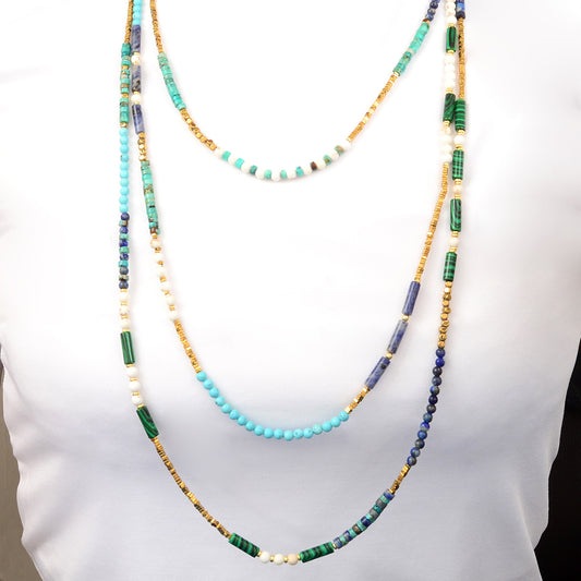 Multistrand beaded necklace with turquoise, green, and gold beads on a white background