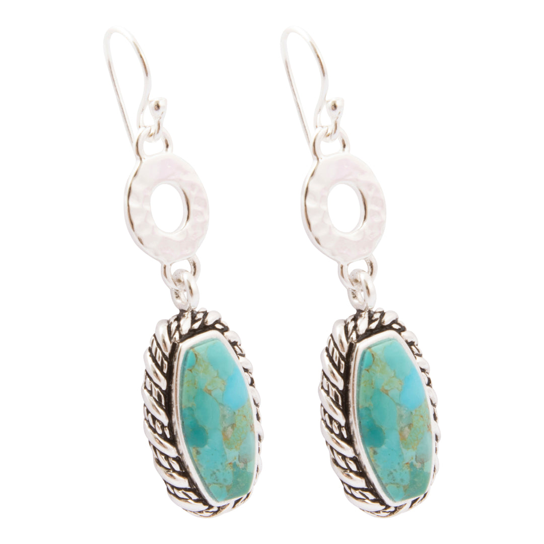 A pair of sterling silver dangle earrings featuring oval turquoise stone pendants with textured silver bezels and hammered silver circular links, shown on a plain white background.
