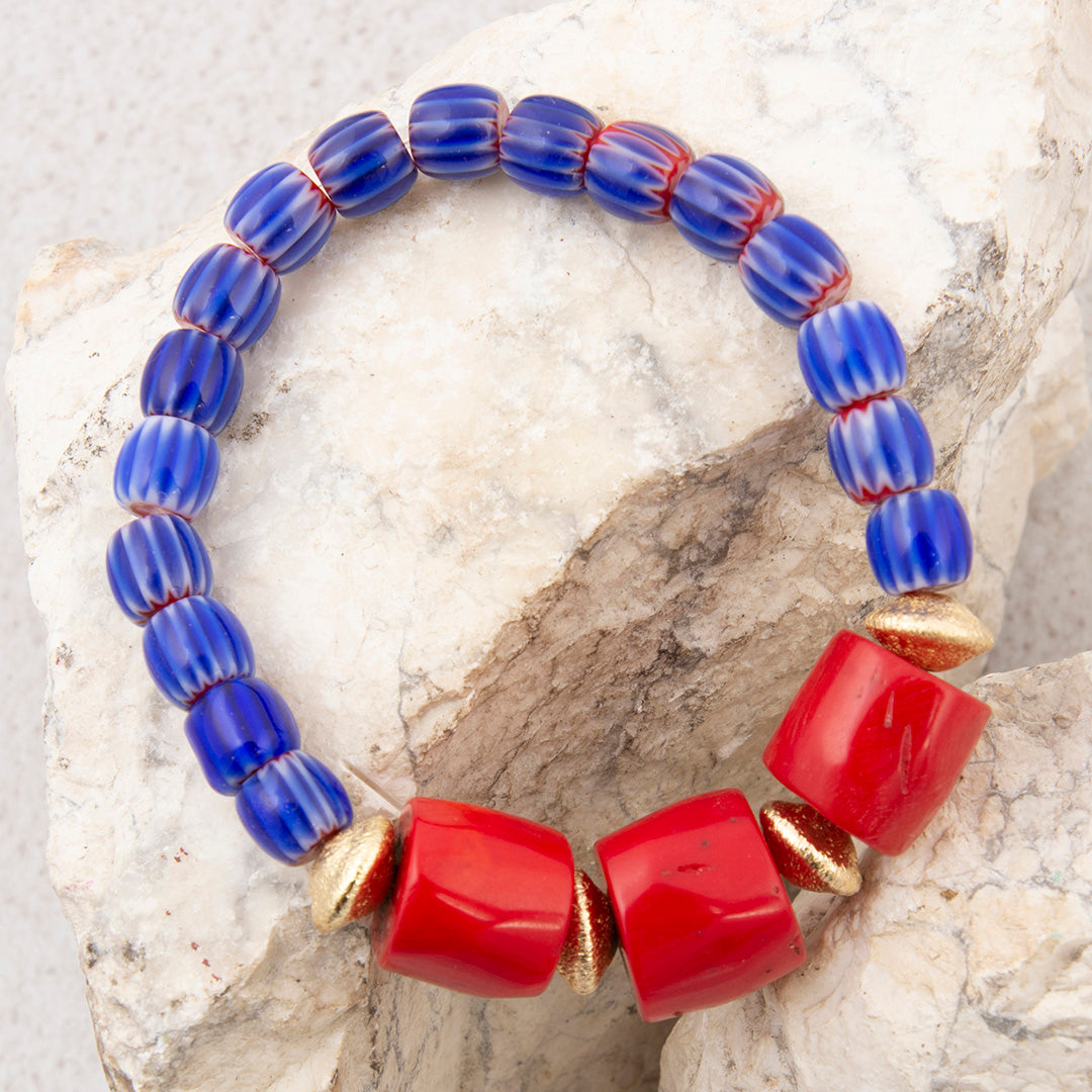Bracelet with blue and red beads on a stone surface