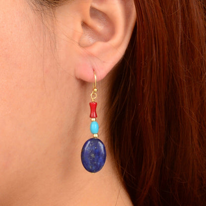 Close-up of an ear wearing a colorful earring with a blue bead.