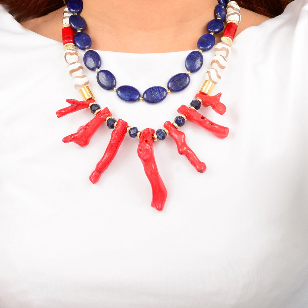 Necklace with red coral and blue beads on a white background