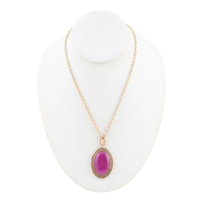 A gold chain necklace with an oval purple cabochon stone pendant, displayed on a white jewelry bust against a white background.