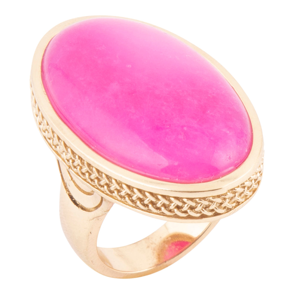 An oval pink gemstone ring with a textured gold-tone band and bezel, shown on a plain white background.