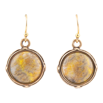 A pair of gold-tone dangle earrings with round bezel-set yellow and brown marbled stone cabochons, shown against a plain white background.