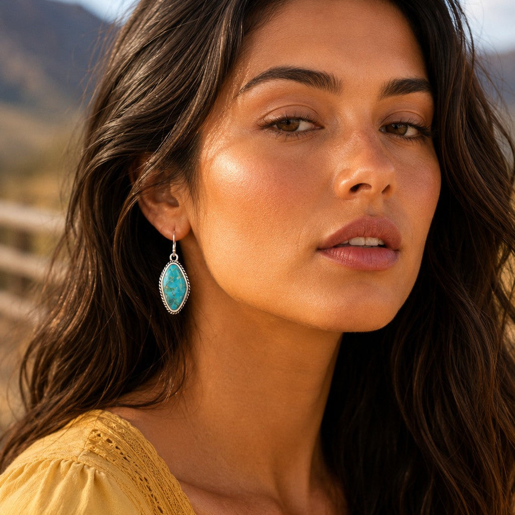 Woman wearing turquoise earrings with a blurred natural background