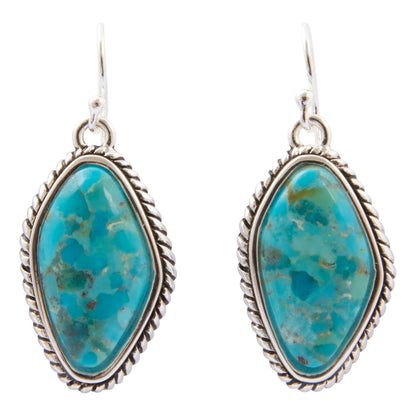 A pair of silver drop earrings featuring organic-shaped turquoise stones with natural brown matrix patterns, set in a twisted rope-style silver bezel, on a plain white background.