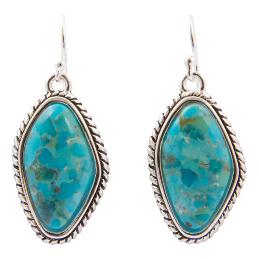 A pair of silver drop earrings featuring organic-shaped turquoise stones with natural brown matrix patterns, set in a twisted rope-style silver bezel, on a plain white background.