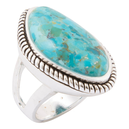 A sterling silver ring featuring a large, oval-shaped turquoise cabochon stone with natural brown matrix veining, set in a textured bezel with a split shank band.