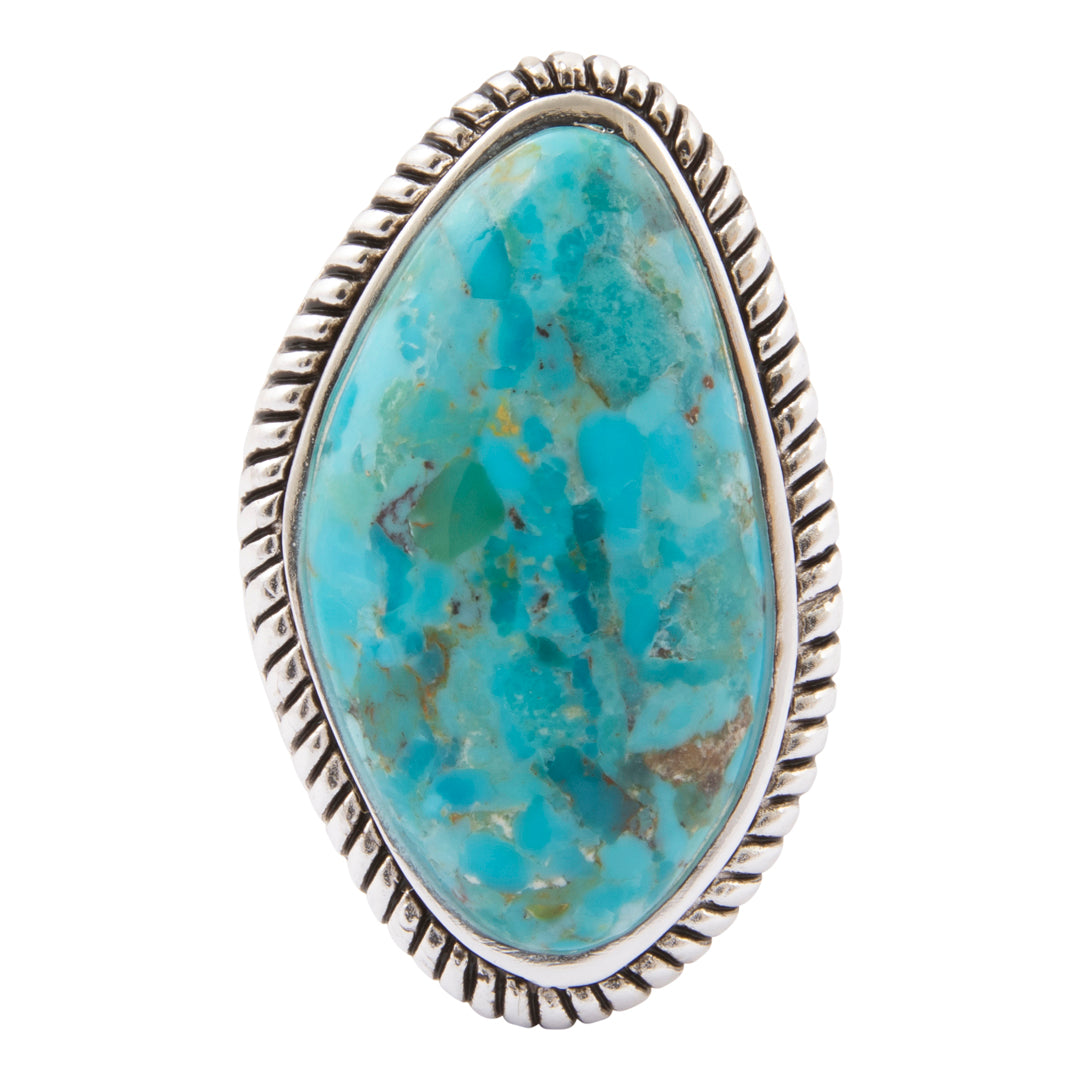 A sterling silver ring featuring a large, teardrop-shaped turquoise stone with natural green and brown matrix patterns, set in a textured, rope-style bezel on a plain white background.