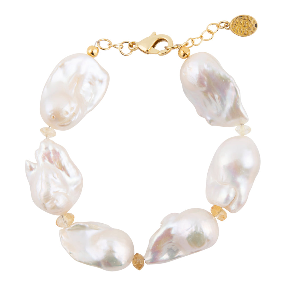 A baroque pearl bracelet with irregular white pearls and small gold spacer beads, connected by a gold chain with a lobster clasp and a round gold brand tag.
