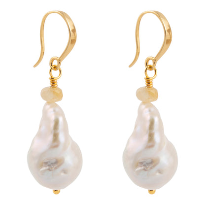 A pair of gold drop earrings featuring irregular, baroque-shaped white freshwater pearls and a small round gold bead below the hooks, set against a plain white background.