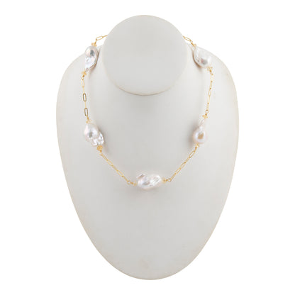 A delicate gold chain necklace with irregular white baroque pearls, displayed on a white mannequin bust against a plain white background.