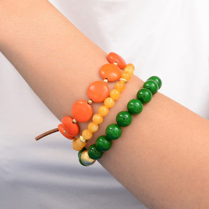 Stack of colorful beaded bracelets on a wrist against a neutral background