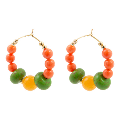 Pair of hoop earrings with orange and green beads on a white background